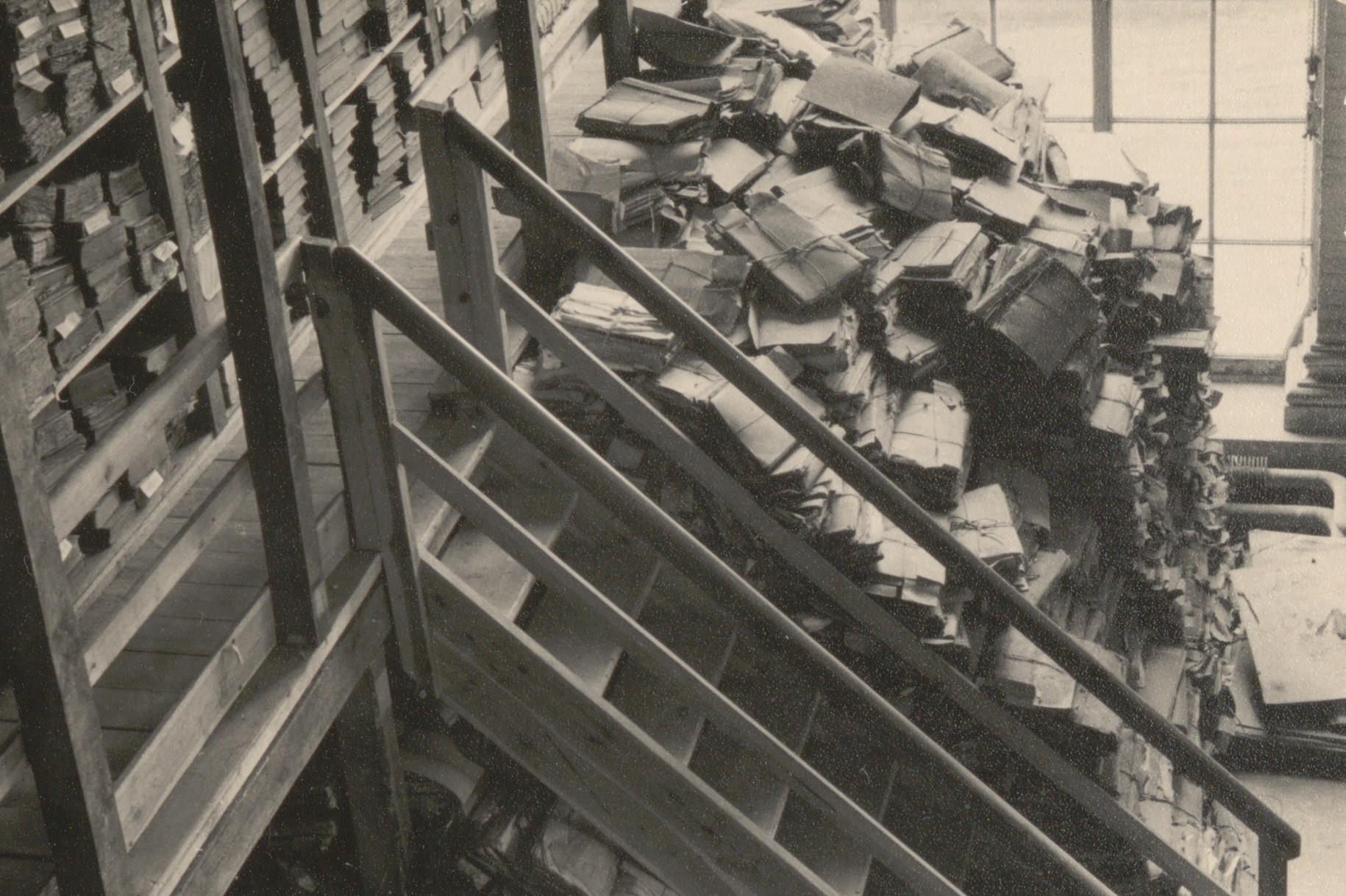 Bild: Ein Schwarz-Weiß-Foto zeigt Aktenberge an einer Treppe am alten Standort der Orangerie um 1950