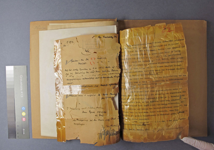 Impending loss of information due to acidic paper, tears, defects and an impressive number of self-adhesive strips