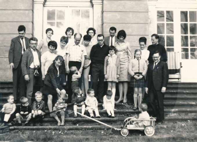 schwarz-weiß Foto einer Gruppe von Erwachsenen und Kindern auf einer Außentreppe